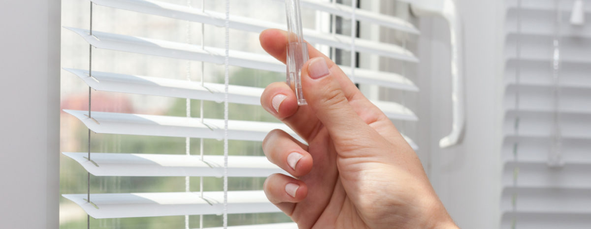image of someone closing window blinds