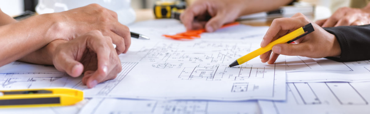 Group of people looking at plans on a table