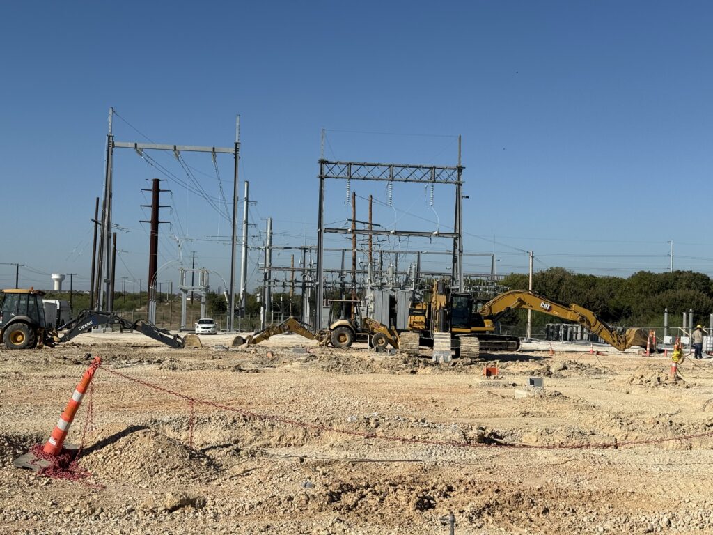 Henne substation upgrade with trucks working to lay poles and transformers.