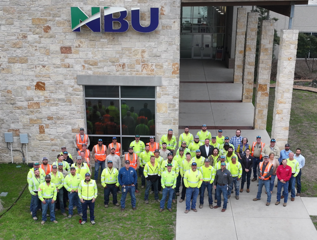 NBU electric, water and wastewater staff pose for a picture with support staff