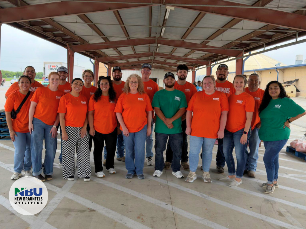 Seventeen NBU employees pose for a photo at the foodbank food distribution.