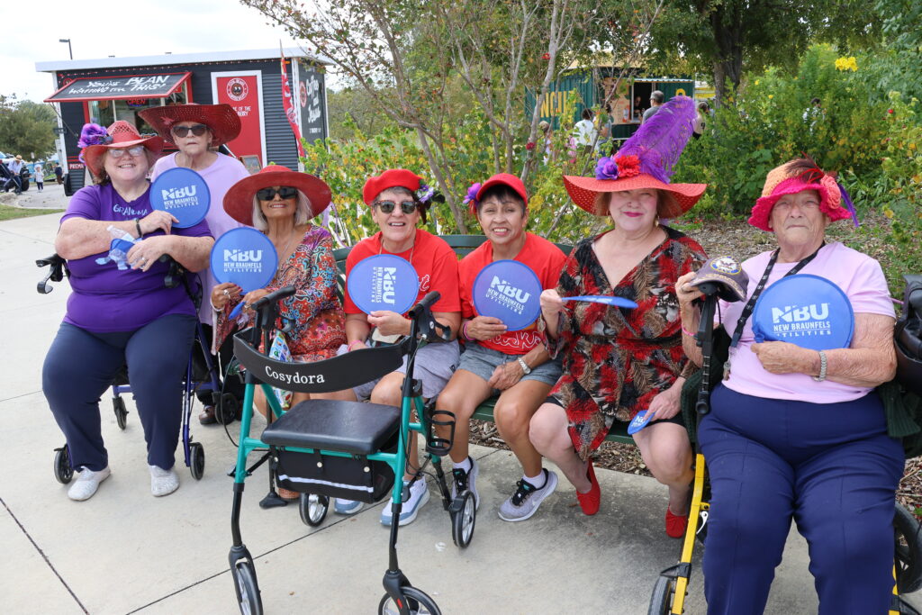 Group of 7 women pose for a photo with NBU hand fans at Monarch Festival
