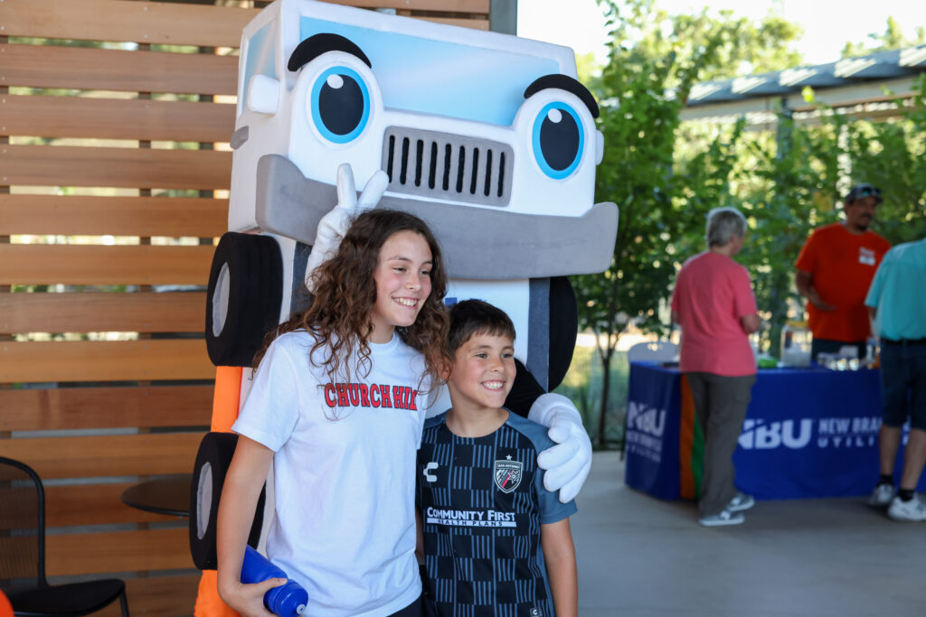 Two children pose with NBU's mascot Axel