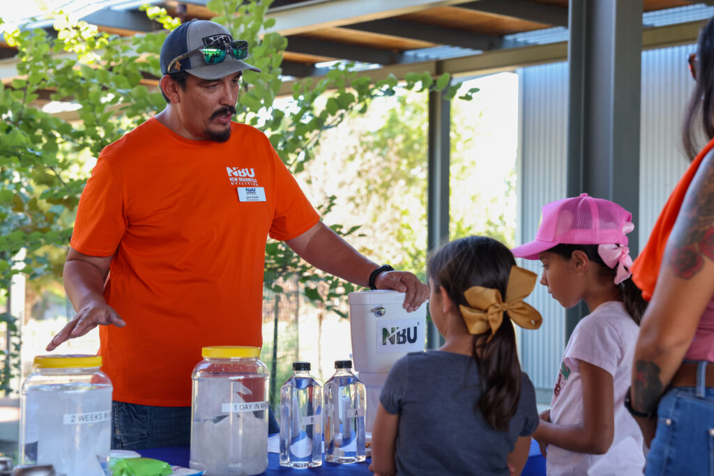 NBU employee talks to a family about water treatment and compliance